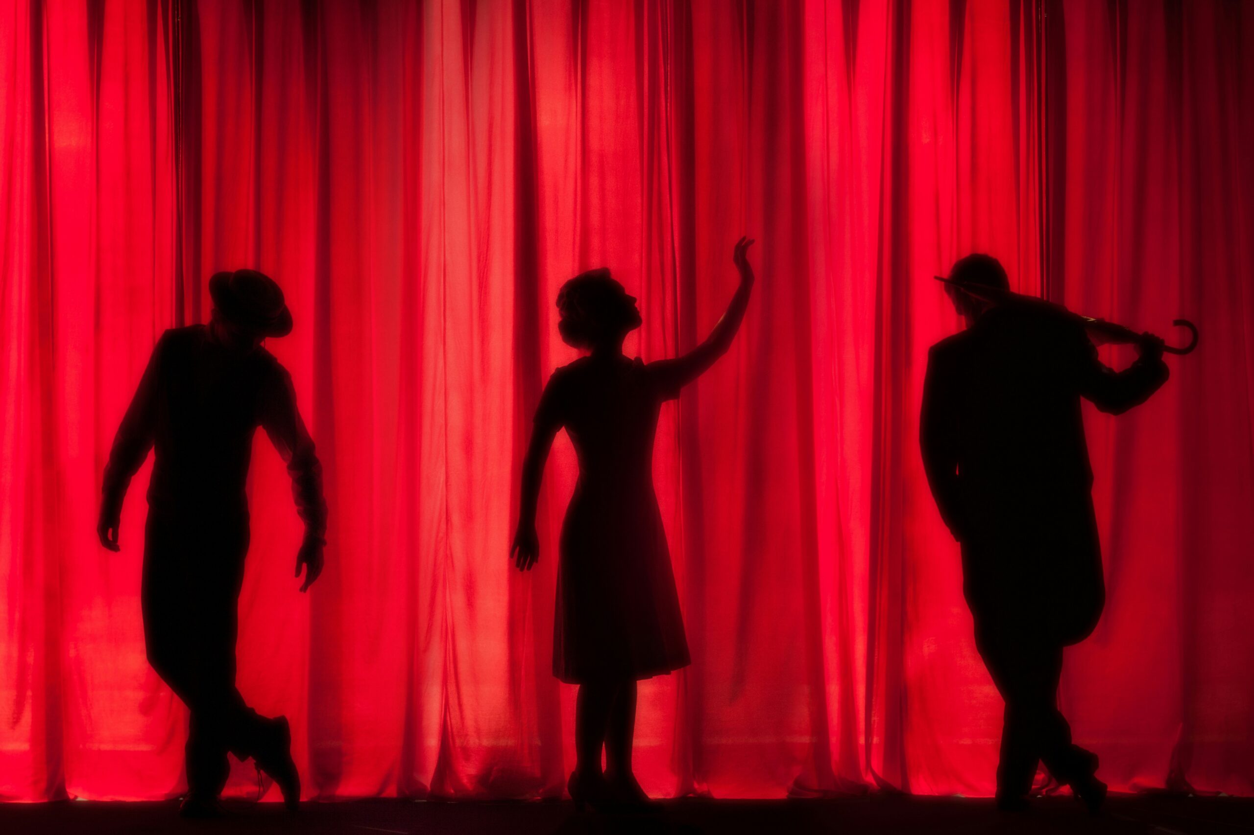 Red curtain with actor silhouettes