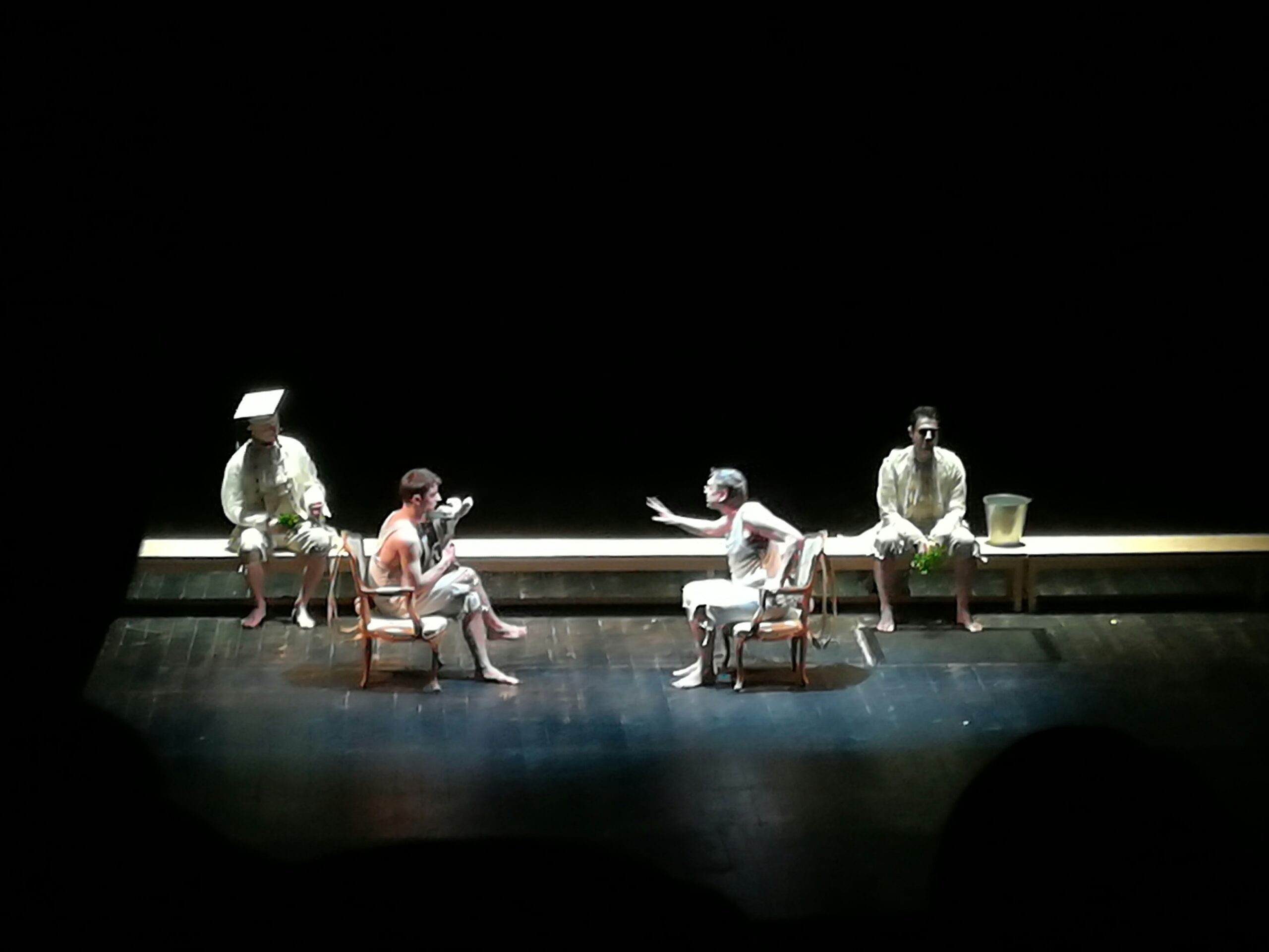 Actors on stage sitting to perform