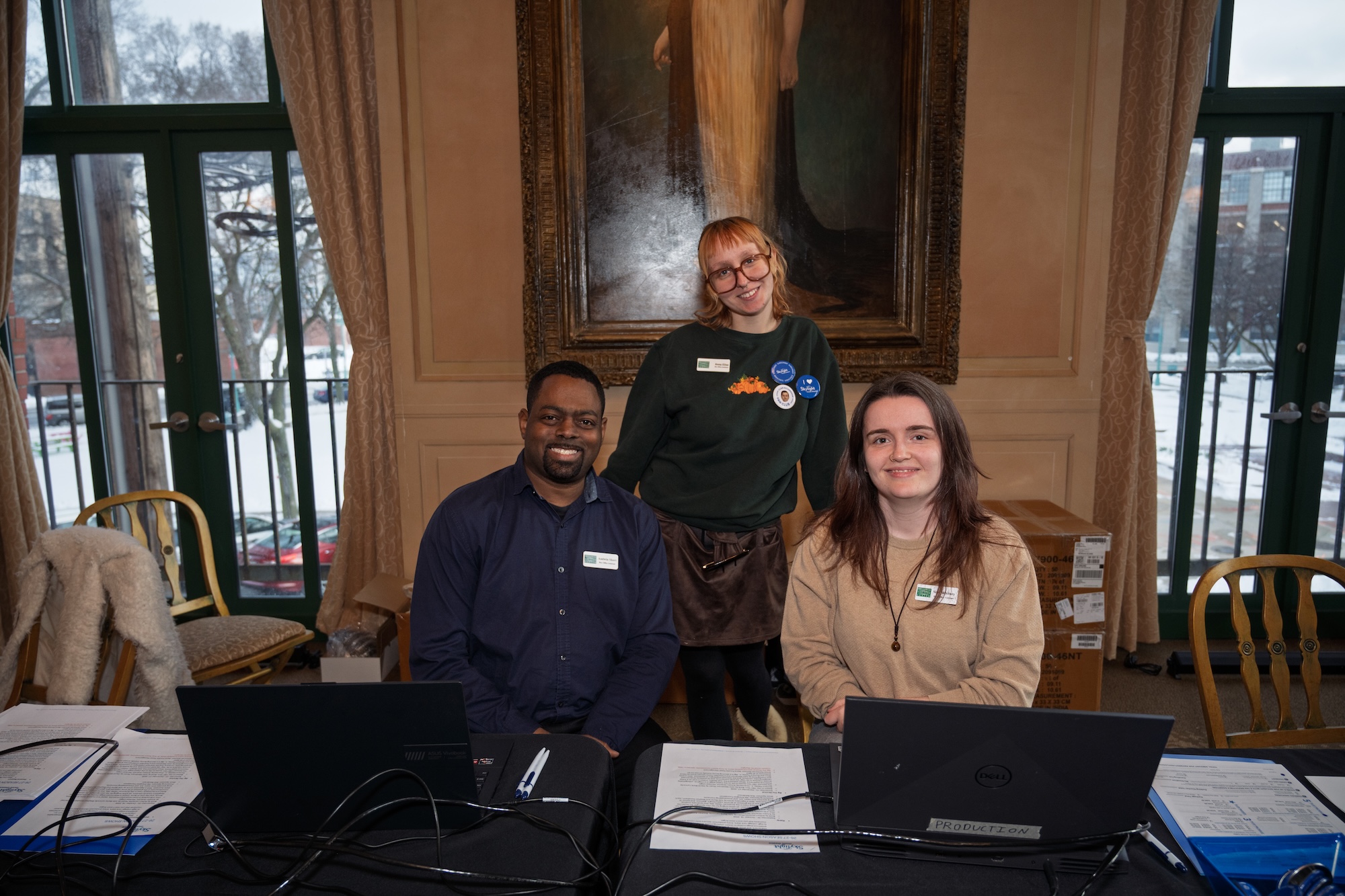 Box office staff sitting and standing and smiling