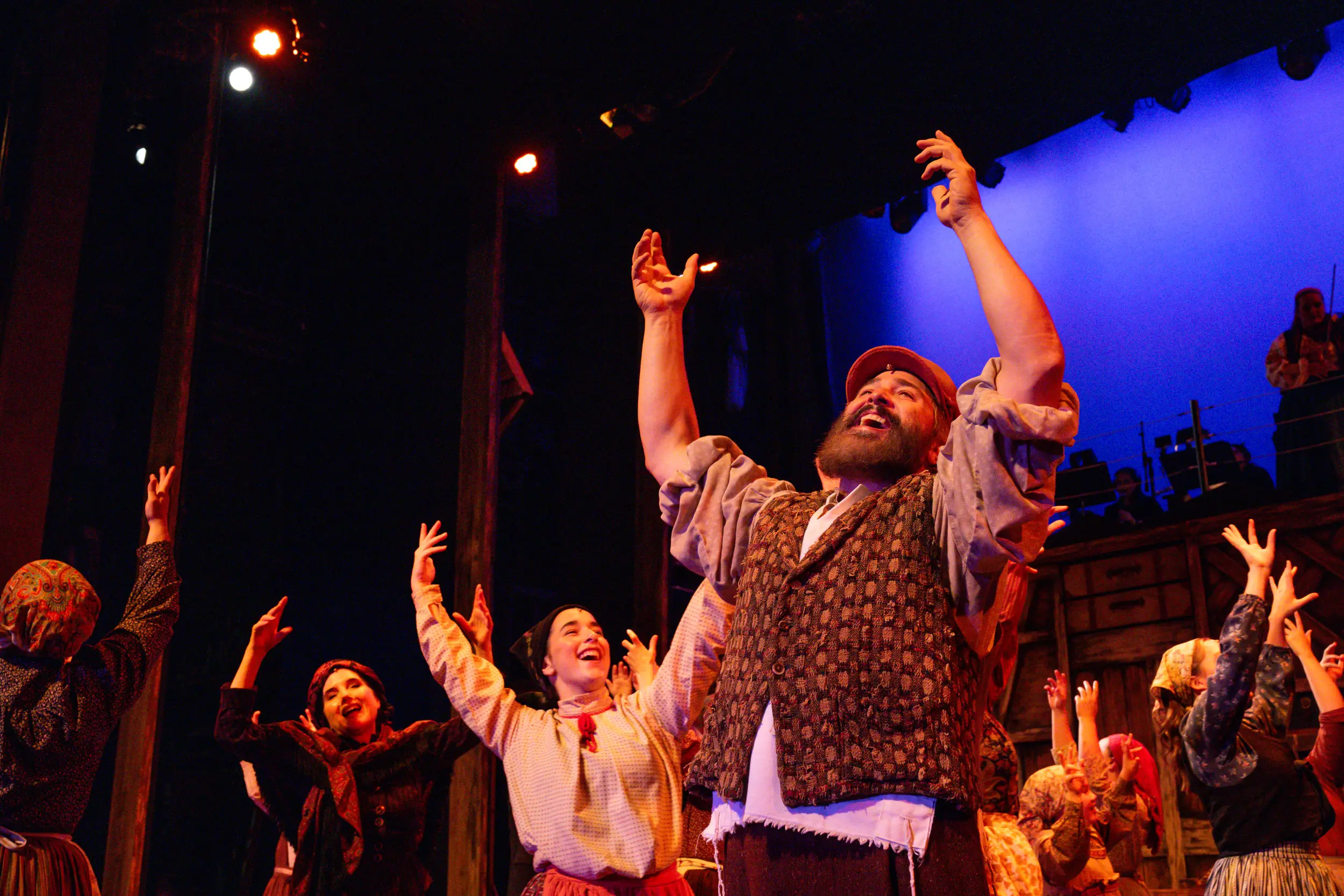 Actors raising hands and signing for a Fiddler on the Roof Performance.