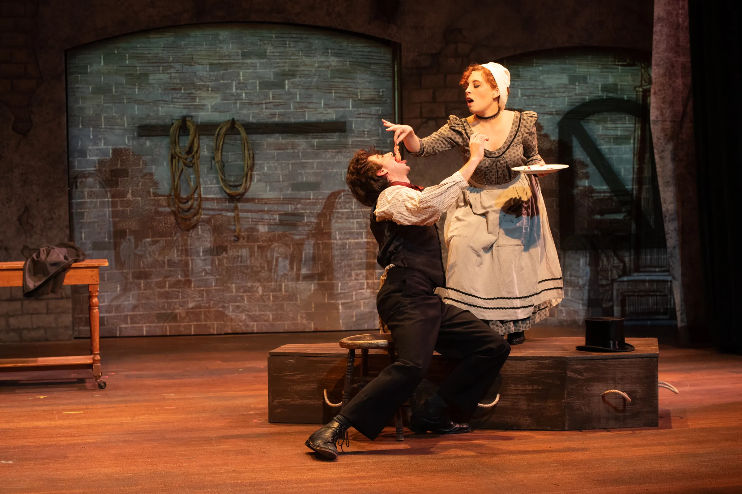 Woman feeding a man meat for Oliver Performance