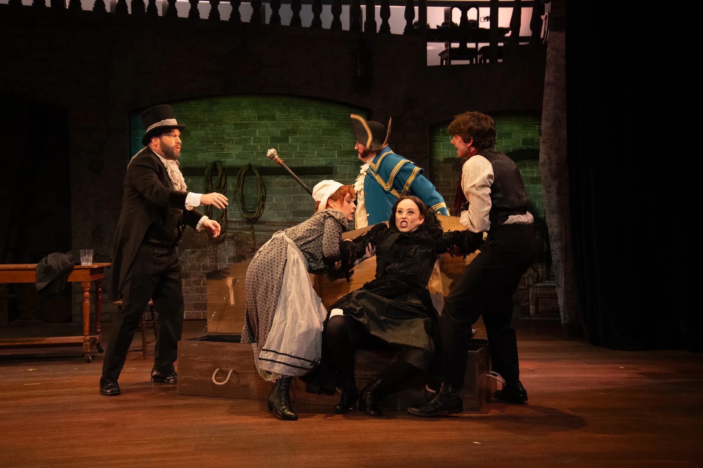 Woman actress being held down during Oliver Performance