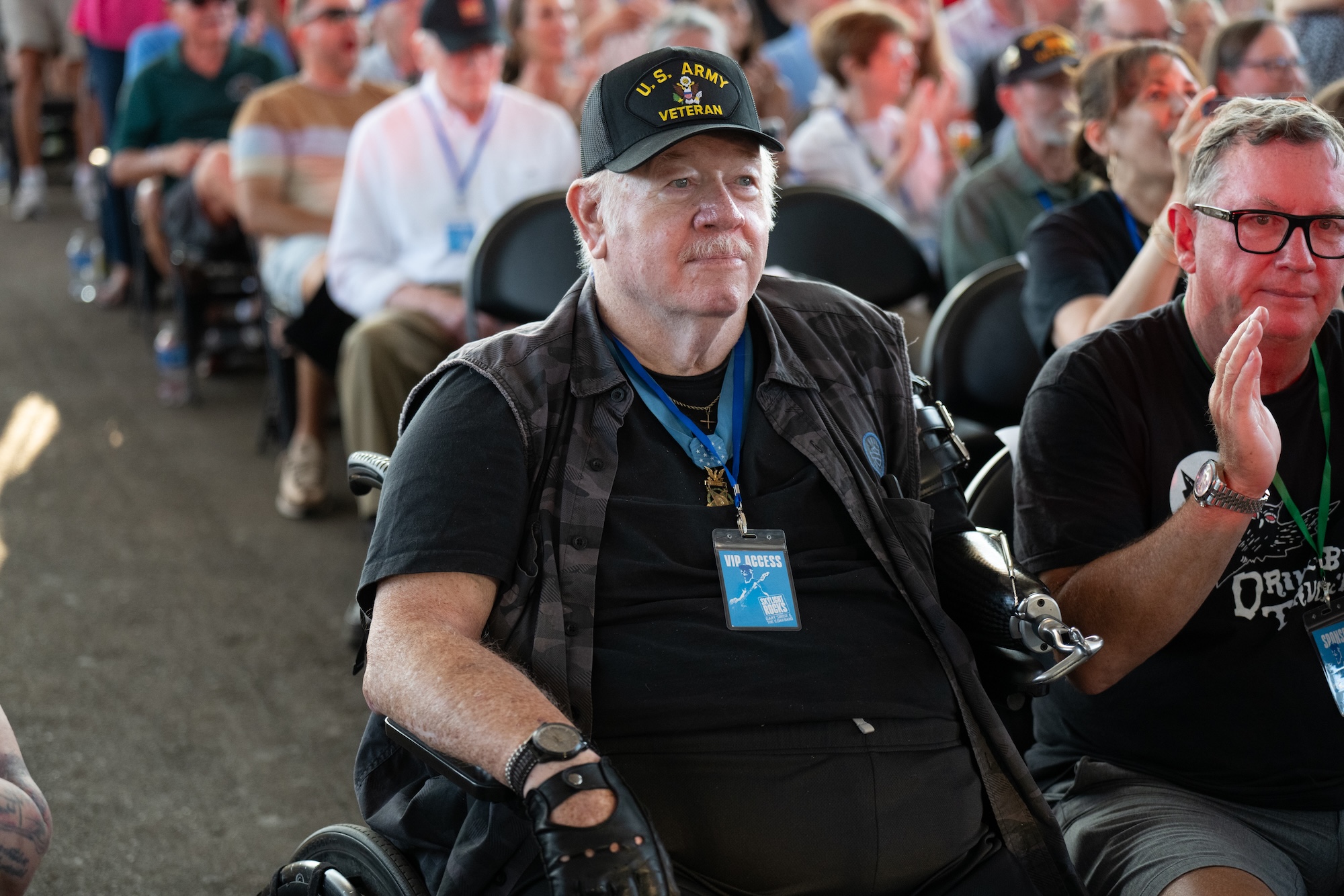 Veteran in a wheelchair in a crowd of seated people
