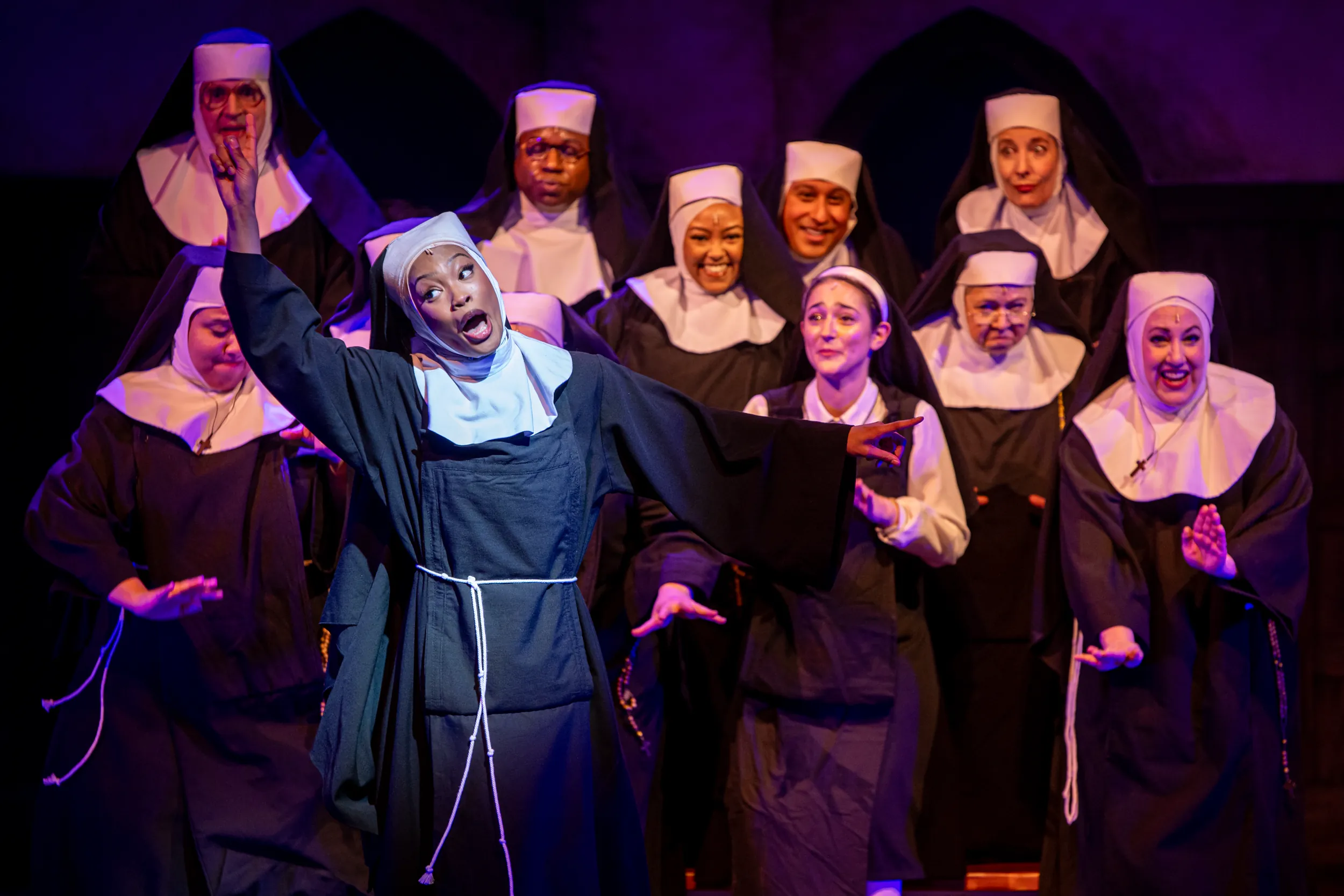 Woman nun singing with backup nuns behind her for Sister Act Performance