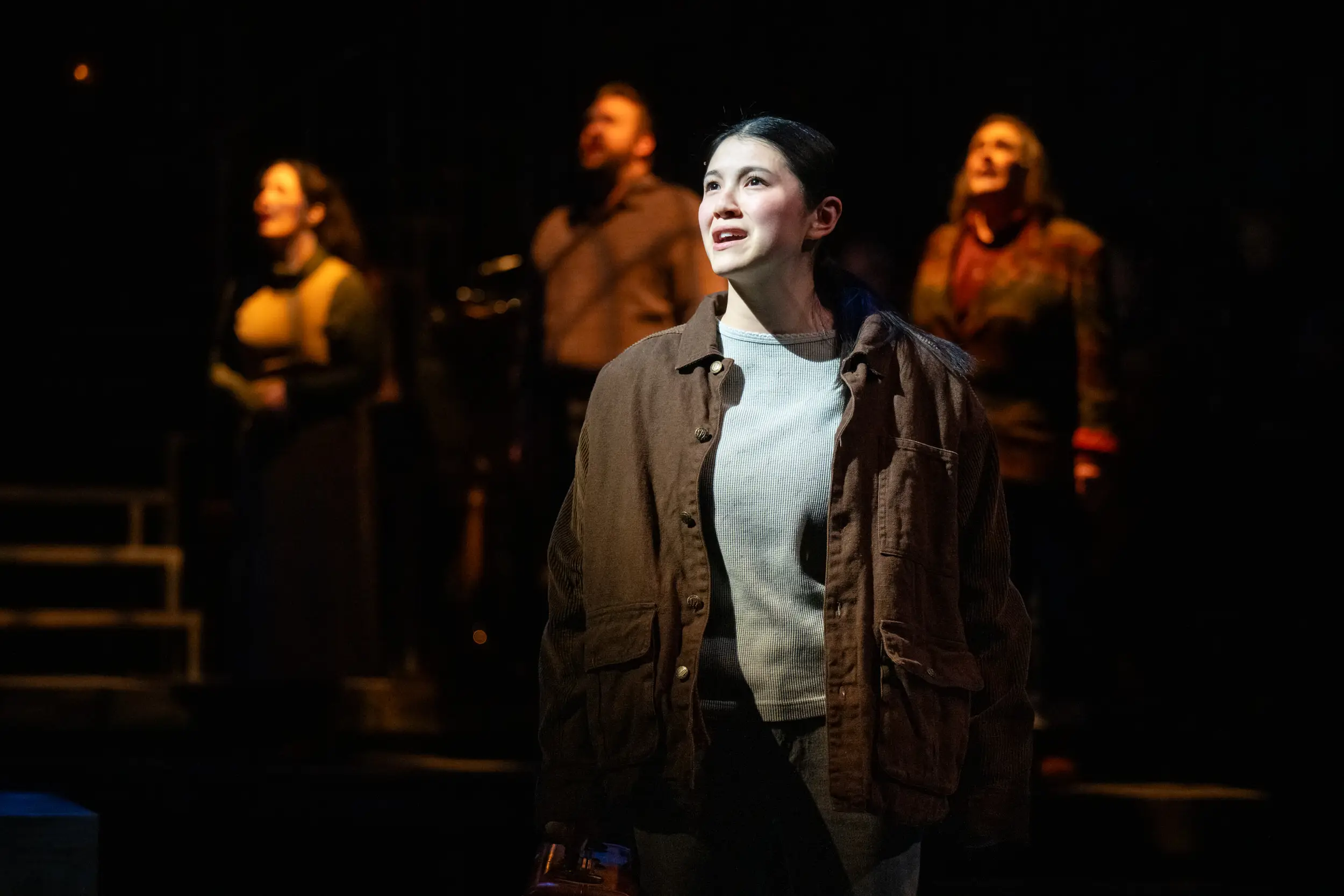 Actress singing with three backup actors as part of Spitfire Grill performance