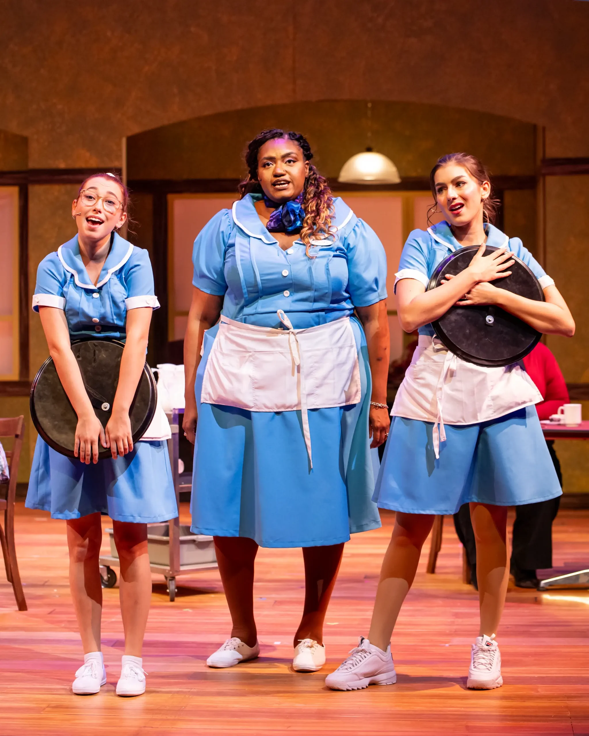 Three waitresses singing during Waitress performance