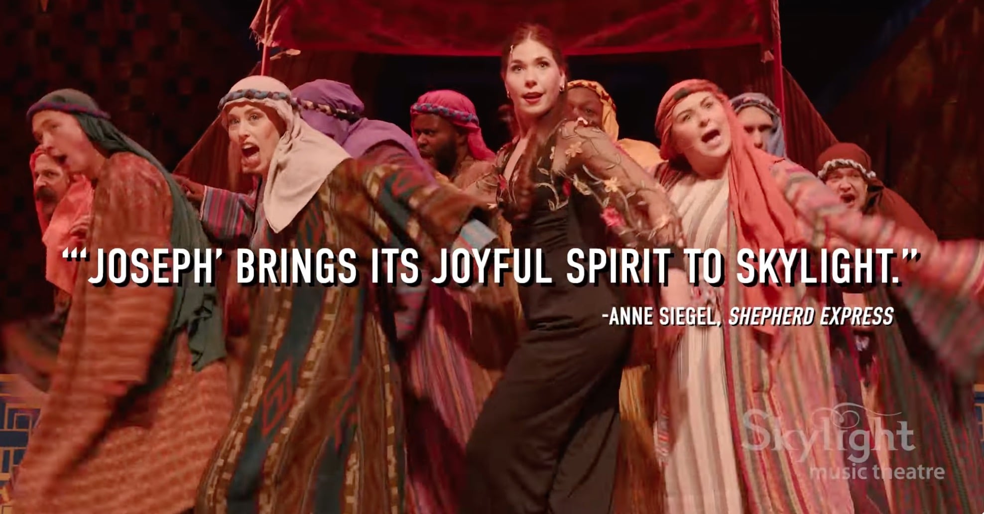 Cast of Joseph and the Technicolor dreamcoat with the quote over it 
