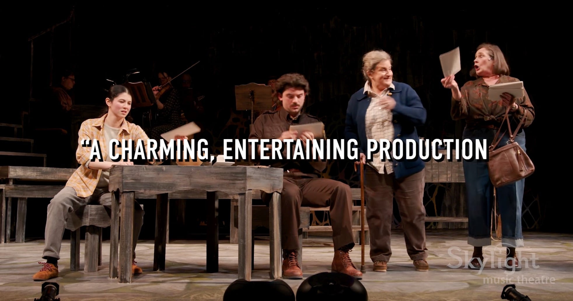 Four actors on stage with the quote 